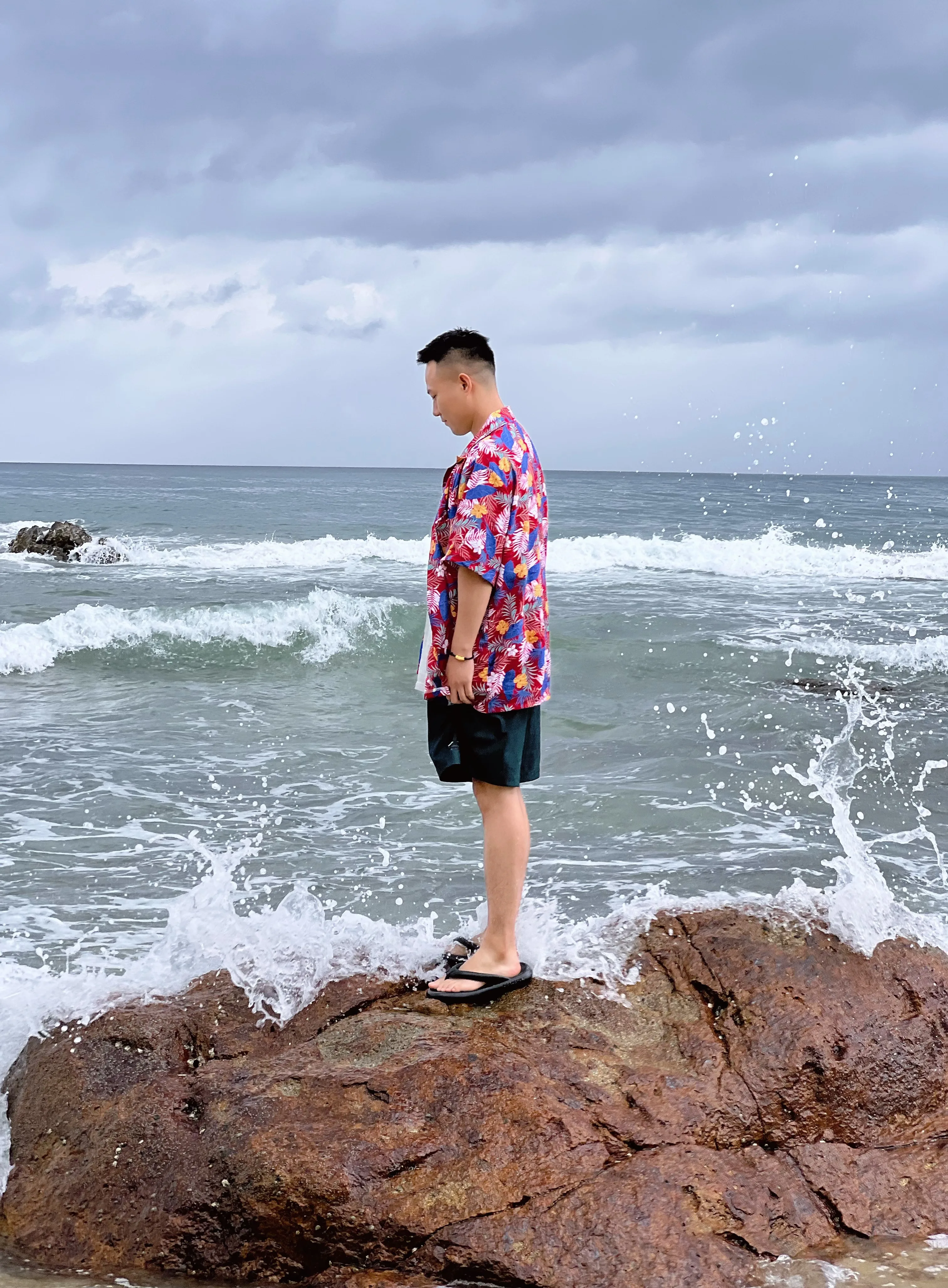 三亚男子站在海边礁石上