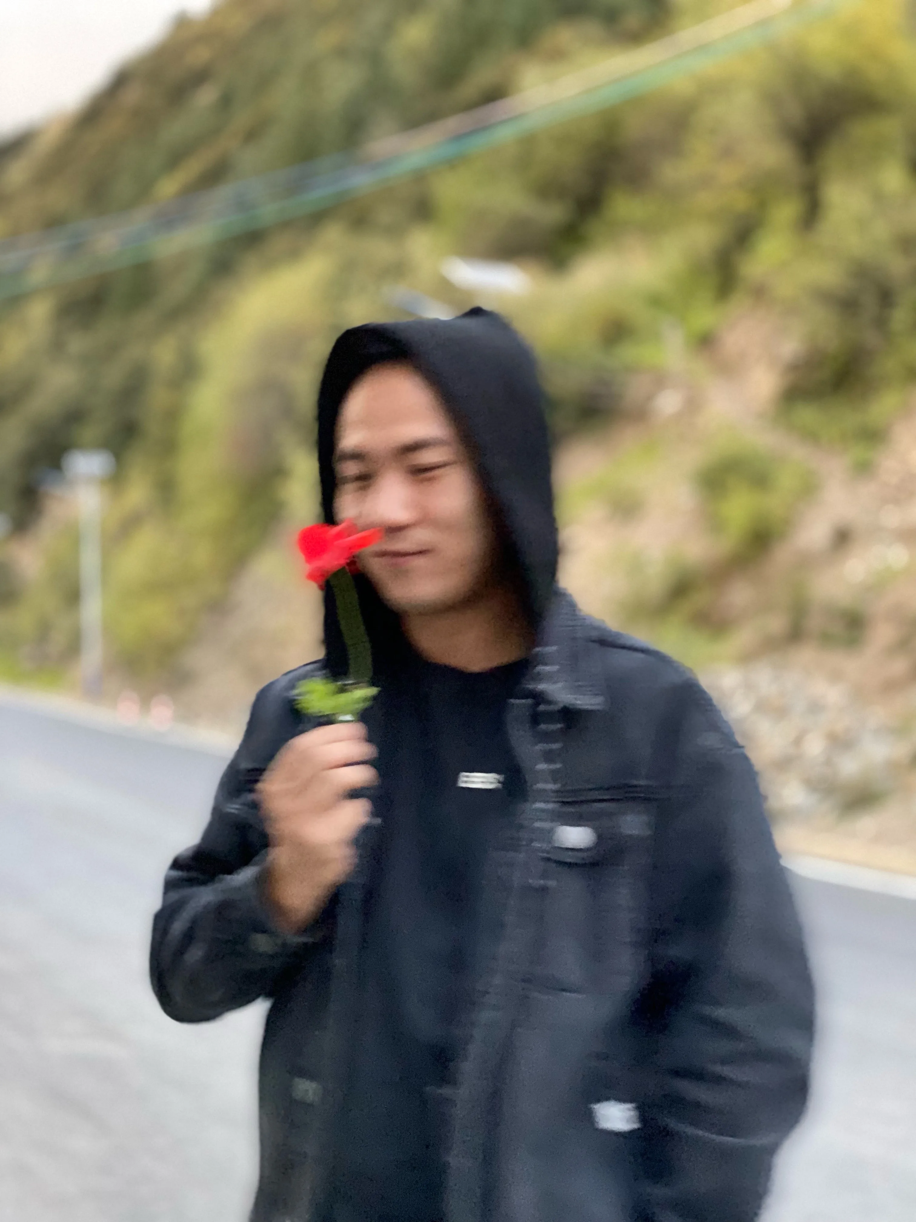 四川山路手持红花的男子